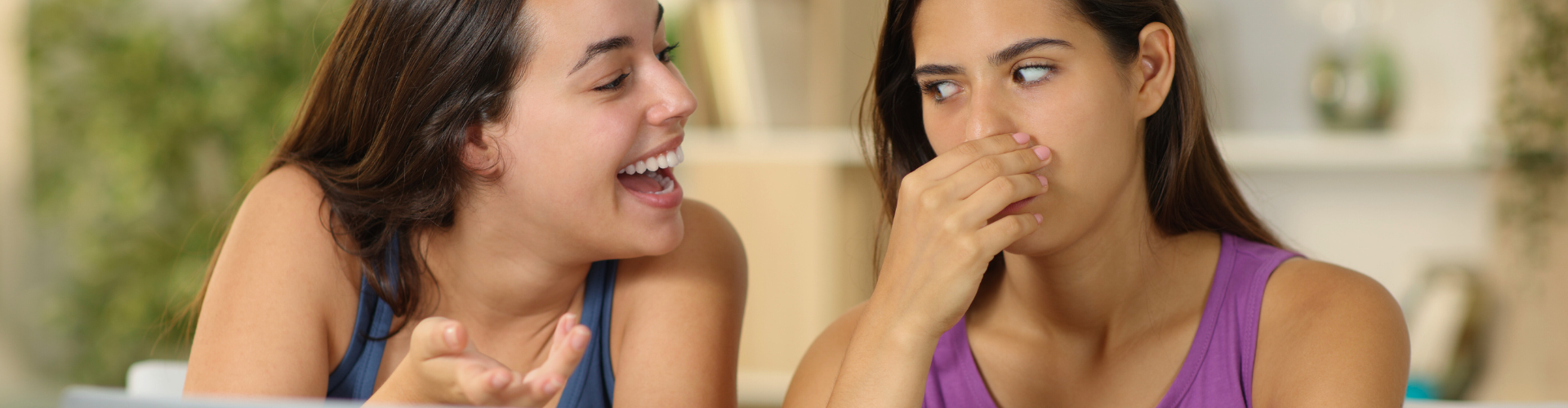Woman talking to a woman covering her nose.